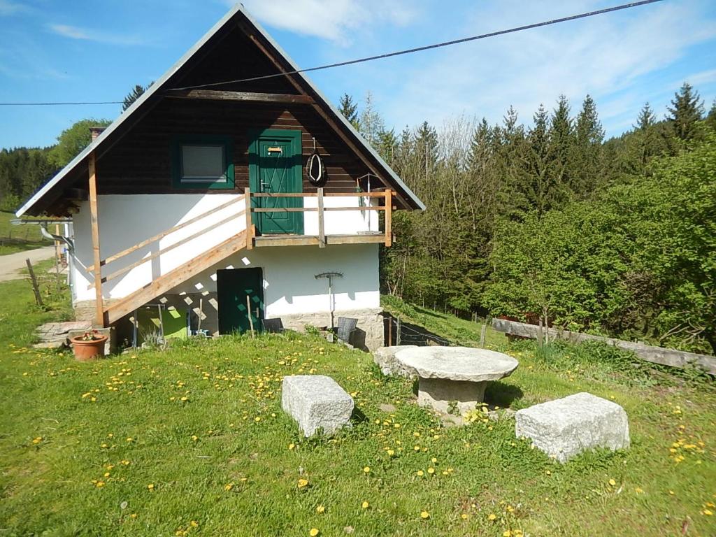 un edificio con dos bancos de piedra delante de él en Ferienhaus am Reitbauernhof Luckyranch, en Mellach