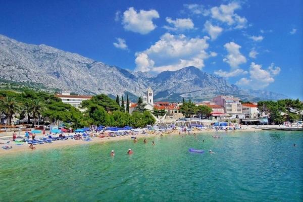 a group of people in the water at a beach at Apartment House Aria in Baška Voda