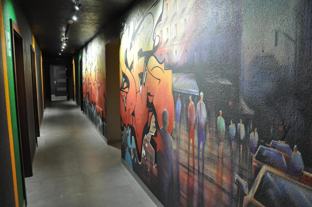 a hallway with a painting on the side of a wall at FULL HOUSE capsule hostel in Rivne