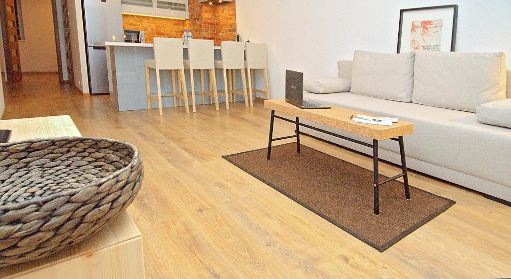 グダニスクにあるIRS ROYAL APARTMENTS Apartamenty IRS Morenowe Wzgórzaのリビングルーム(白いソファ、テーブル付)