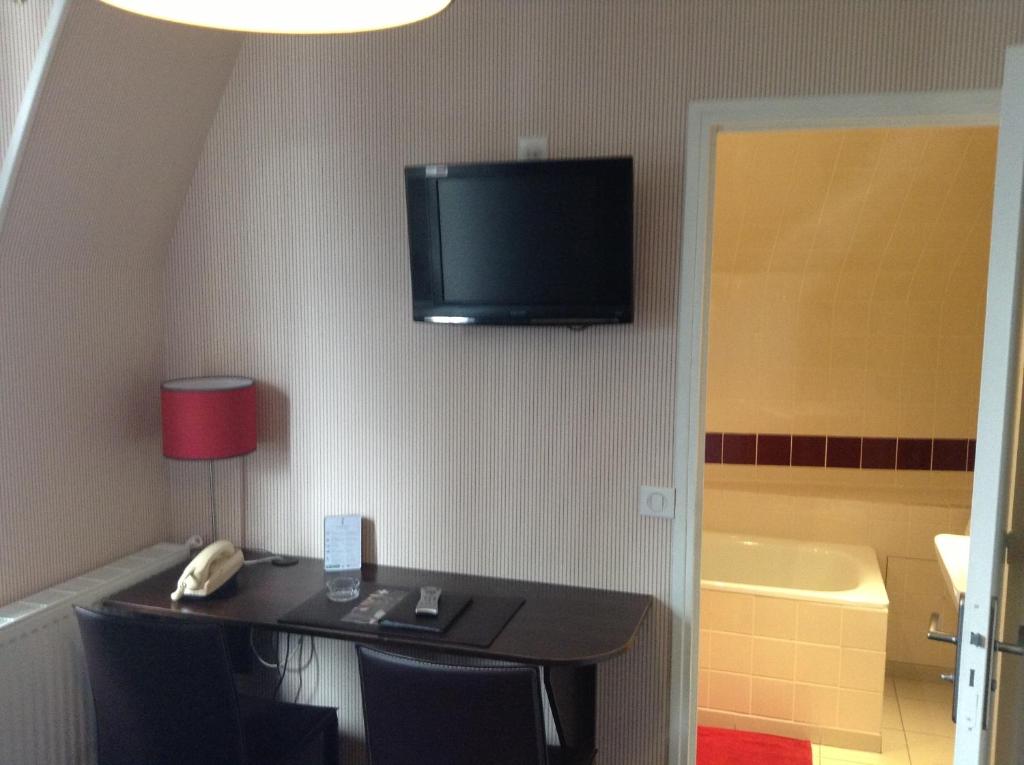 TV a/nebo společenská místnost v ubytování Logis Terrasse Hôtel