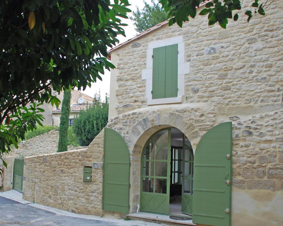 ユゼスにあるMaison de charme Uzès, parking privéの緑のドアと窓のある石造りの建物
