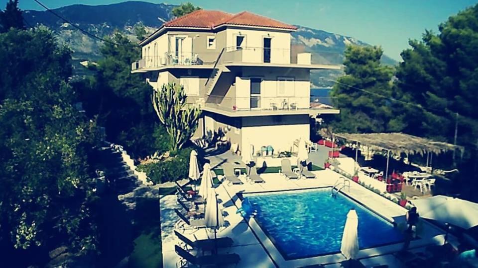 a large house with a swimming pool in front of it at Pessada Bay Studios and Apartments in Pesádha