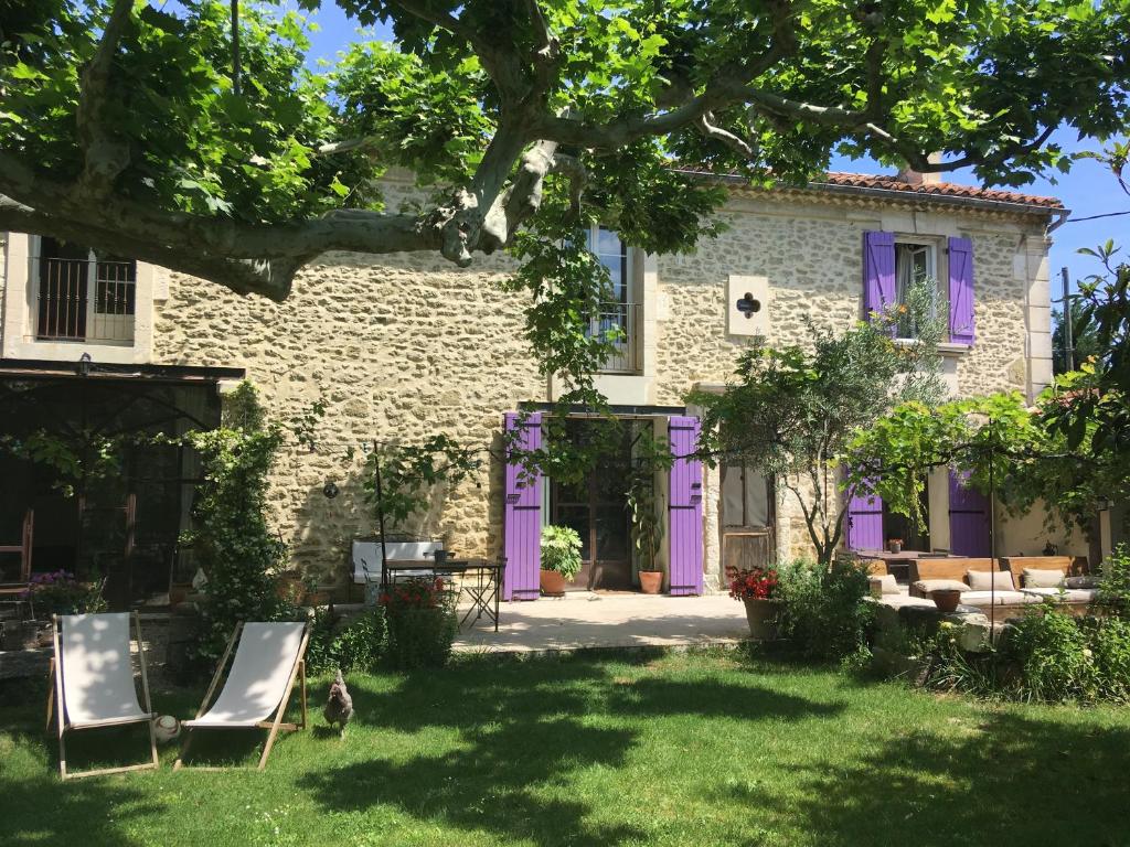 a house with purple doors and chairs in the yard at Mas de Rey in Rognonas