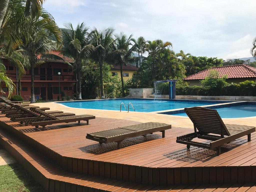 a pool with lounge chairs and a swimming pool at Lindo Flat em Maresias, 100m da Praia in Maresias