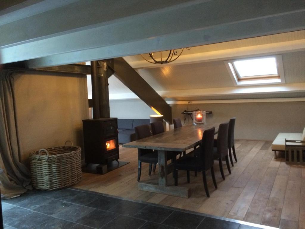 a dining room with a table and a wood stove at In de Schuur in Ochten