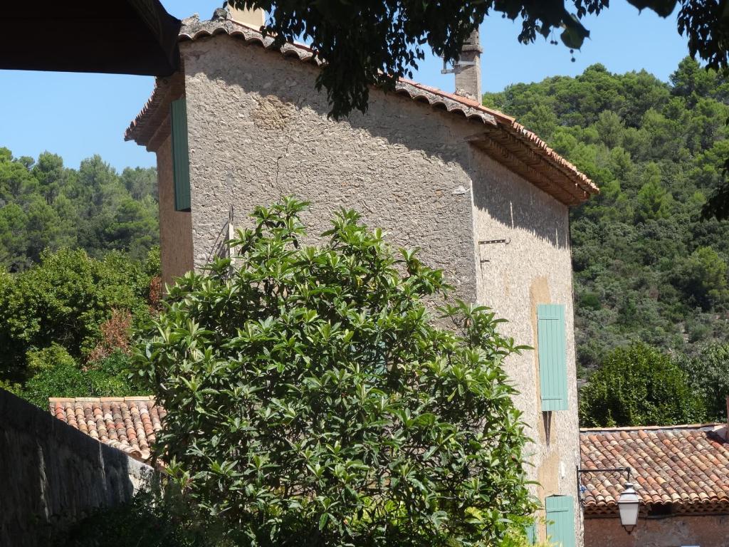 a building with a tree in front of it at Gîte LA BOUSCARLE in Moissac-Bellevue