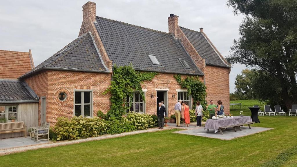 un grupo de personas parados fuera de una casa en Holiday Home Victoria Fields en Diksmuide