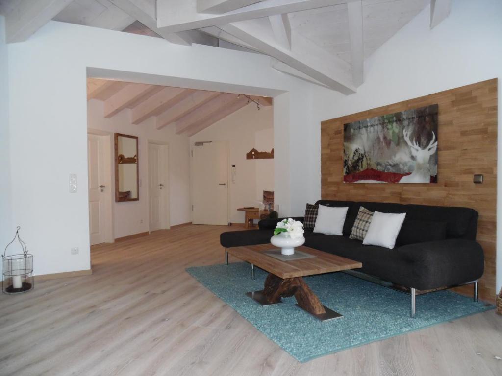 sala de estar con sofá negro y mesa en Apartment Partenkirchen, en Garmisch-Partenkirchen