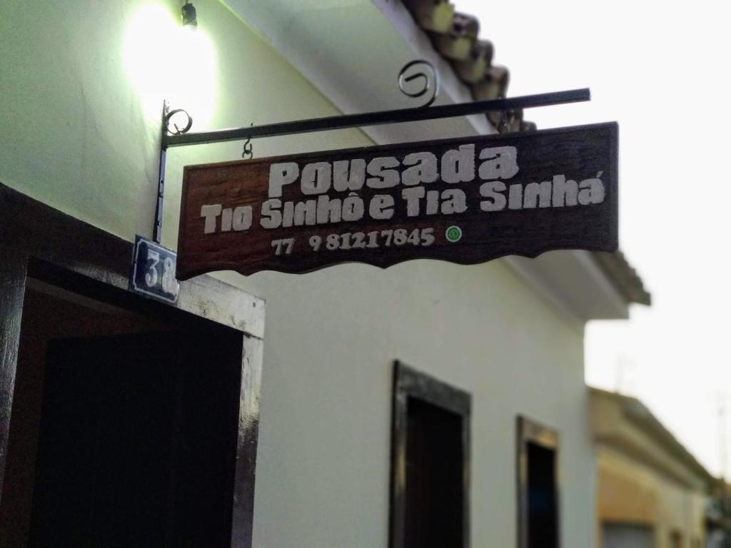 un panneau suspendu sur le côté d'un bâtiment dans l'établissement Pousada Tio Sinhô e Tia Sinhá, à Rio de Contas
