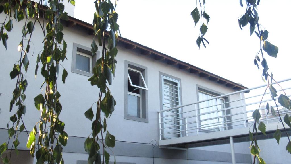 - un bâtiment blanc avec un balcon sur le côté dans l'établissement Departamentos R y R Italia, à Tandil