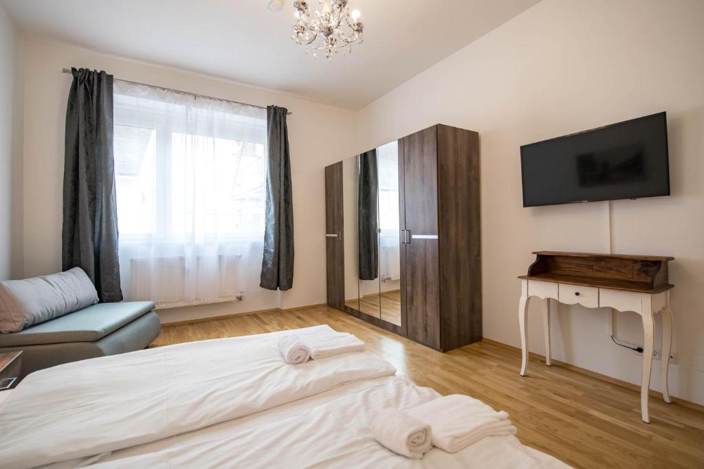 a hotel room with two beds and a television at Minihotel Graz Apartments in Graz