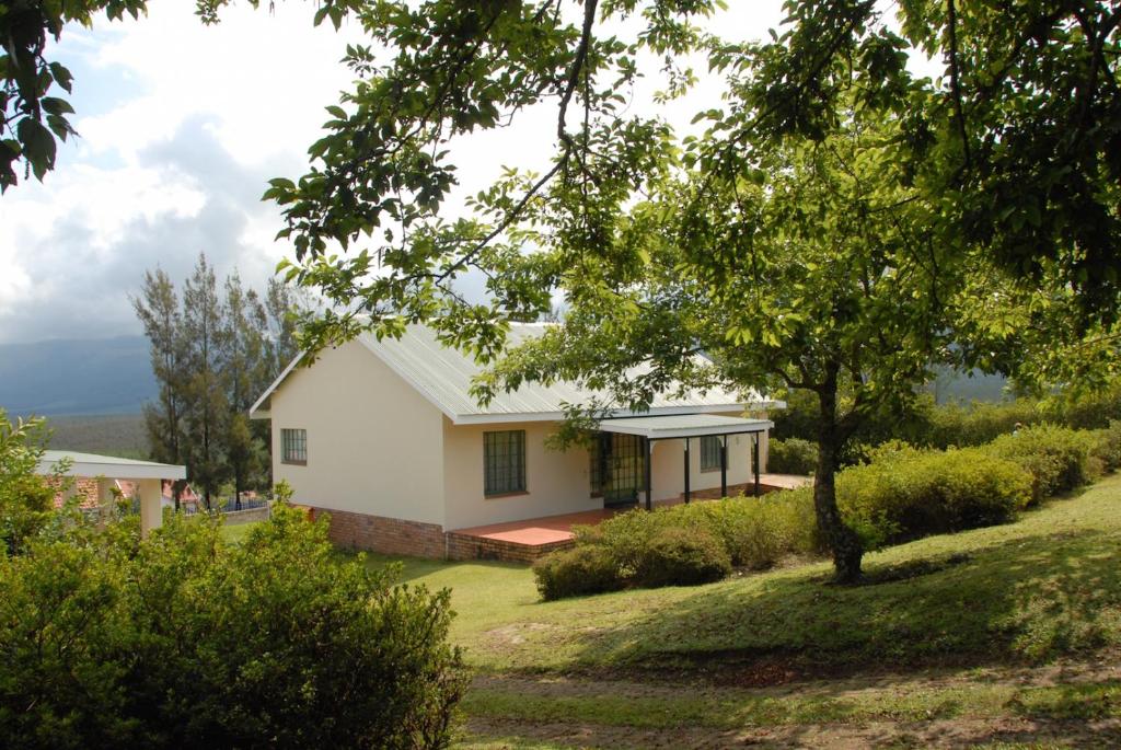 a house on top of a hill with trees at Kloofsig Holiday Cottages in Graskop