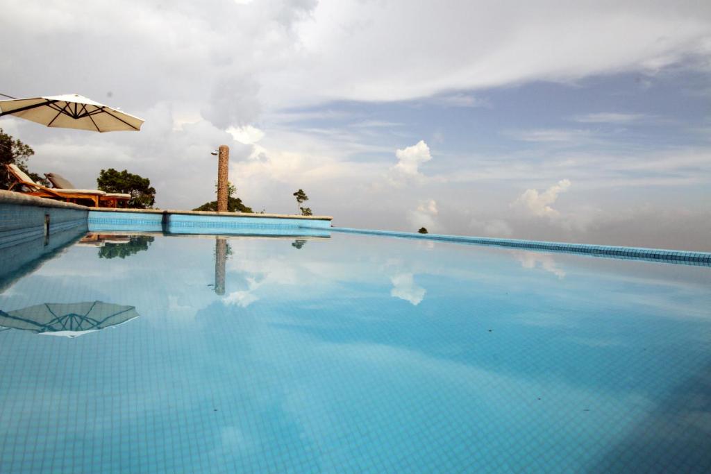 una piscina con ombrellone e cielo di Finca Hamburgo La Ruta del Cafe a Tapachula