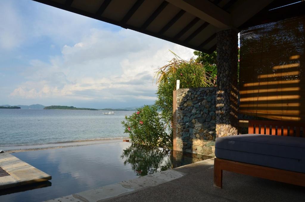 a view of the ocean from a house with a couch at Cocotinos Sekotong Lombok in Sekotong