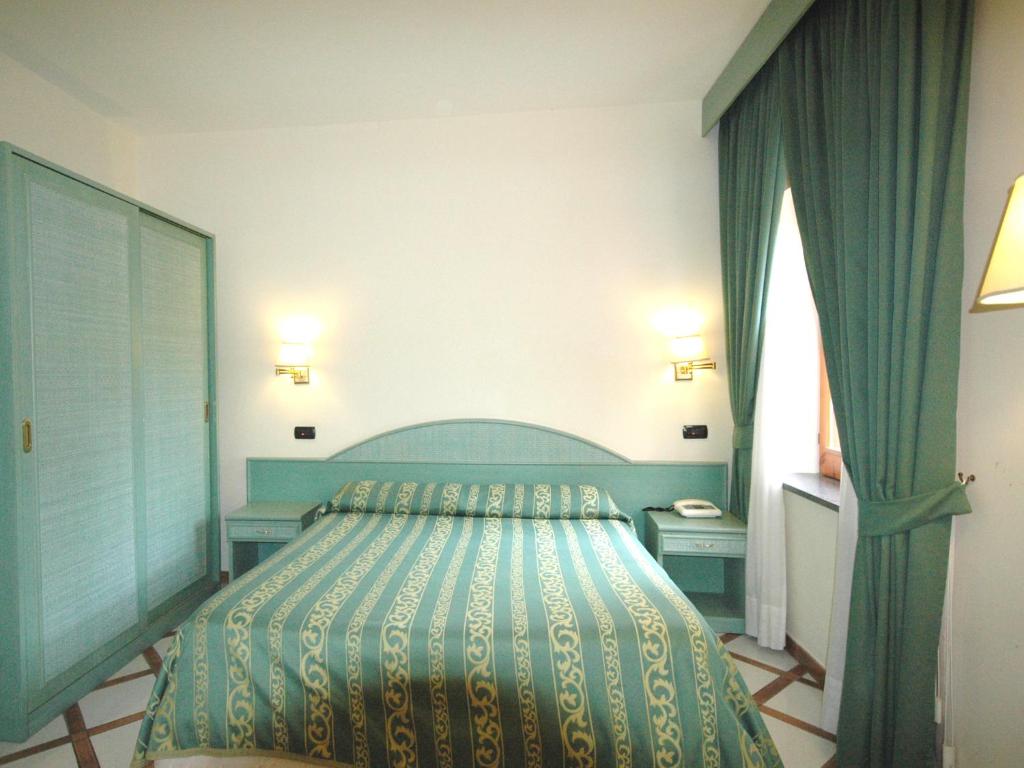 a bedroom with a bed with a blue bedspread at Residence Villaggio Verde in Sorrento