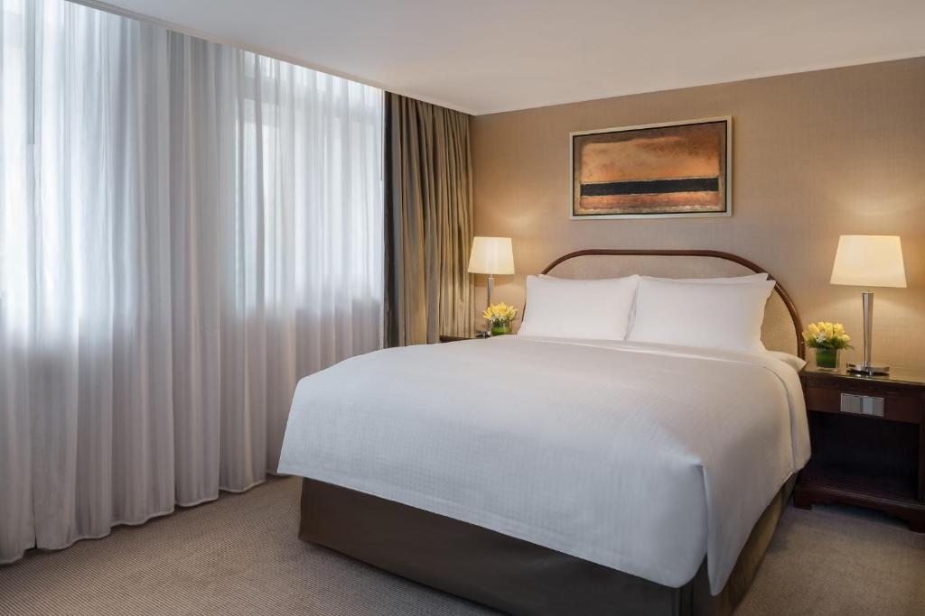 Postel nebo postele na pokoji v ubytování Marco Polo Hongkong Hotel