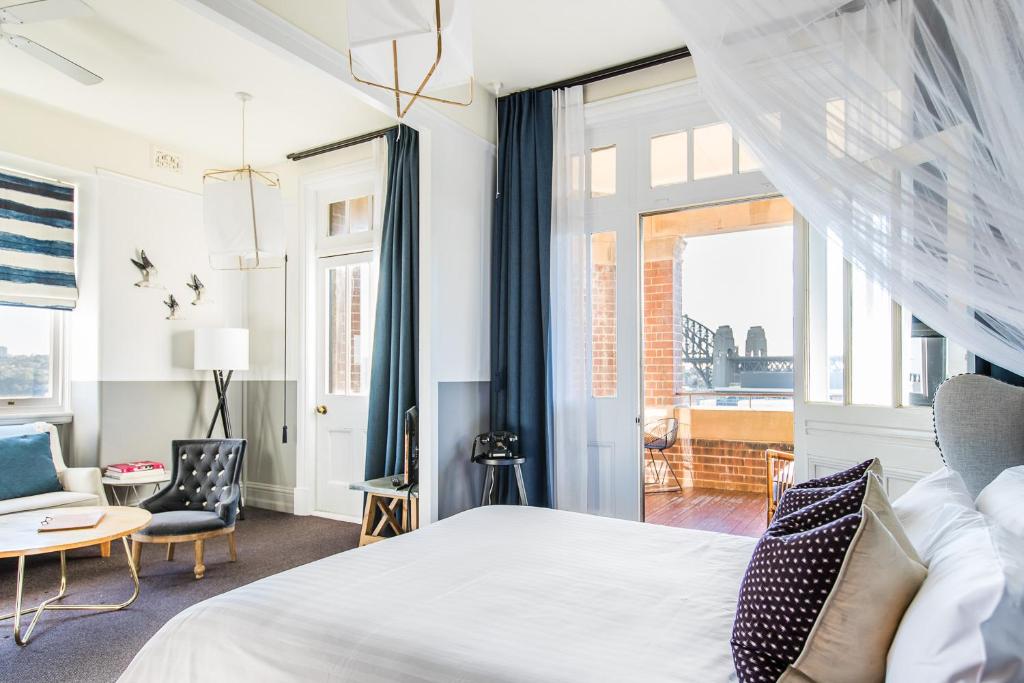 a bedroom with a bed and a chair and a window at Hotel Palisade in Sydney