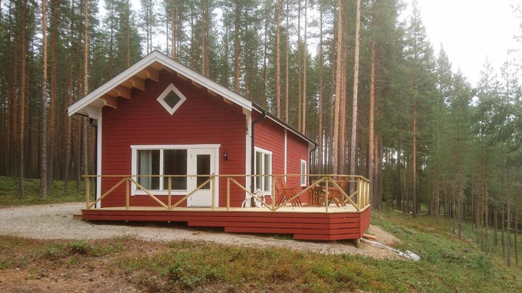 a red cabin in the middle of a forest at Zorbcenter Holiday Homes in Hammarstrand