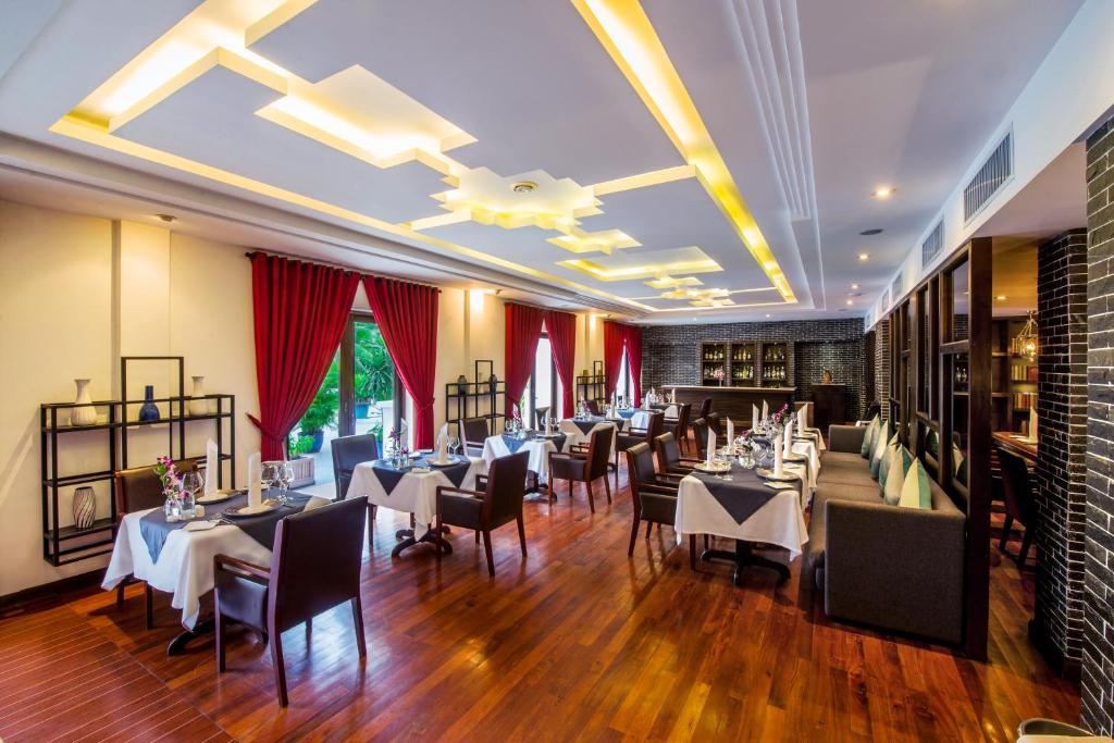 a dining room with white tables and chairs at Lotus Blanc Resort in Siem Reap
