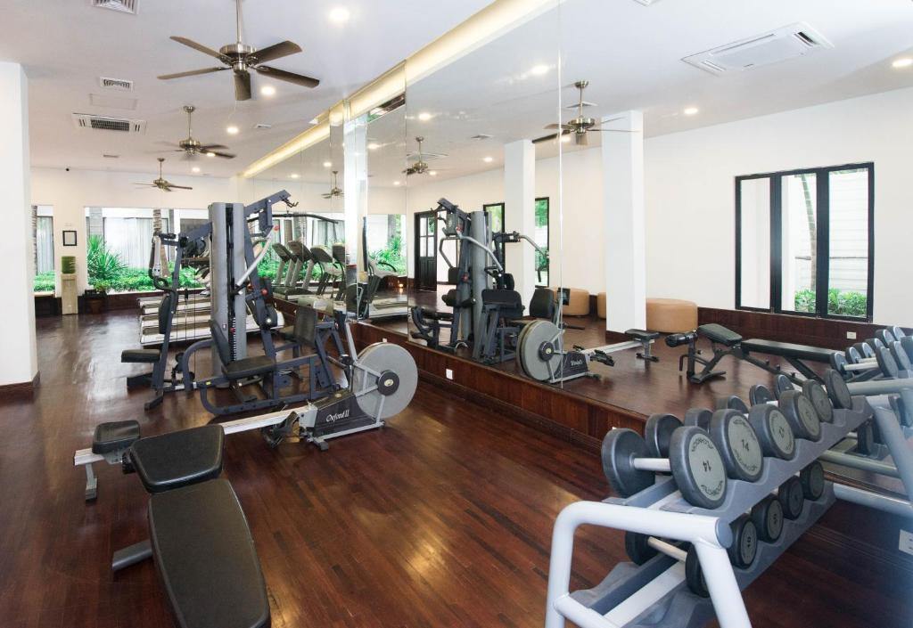 a gym with treadmills and machines in a room at Lotus Blanc Resort in Siem Reap