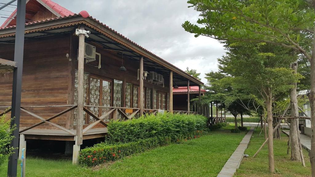 Ban NoiにあるIngaun Resort Kanchanaburiの大きな木造の建物(窓、植物あり)