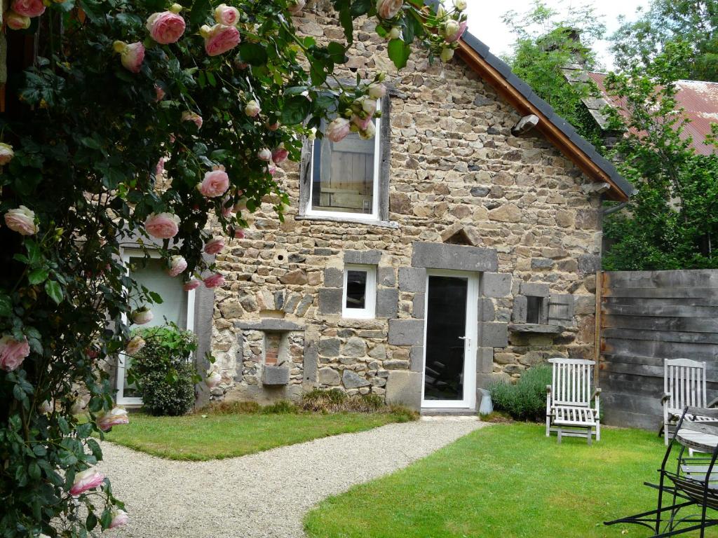 an old stone house with two chairs and roses at Suites de Campagne Les Eydieux, petits déjeuners inclus in Saint-Angel