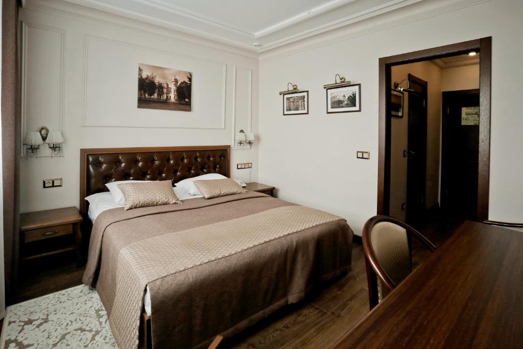 a bedroom with a large bed and a table at Hotel Oktyabrskaya in Ulyanovsk