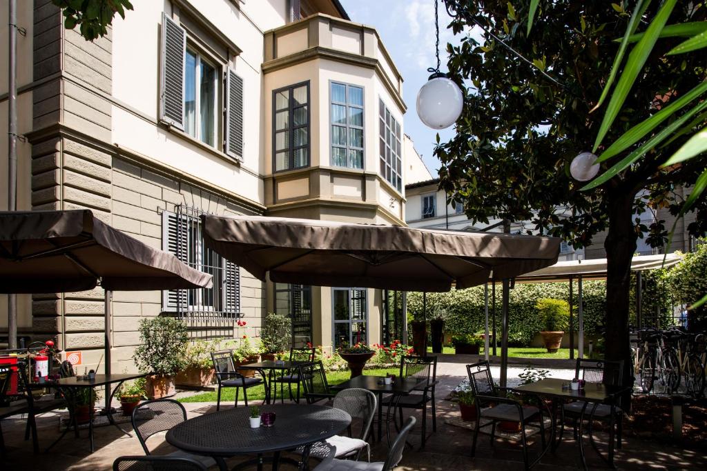 a patio with tables and chairs and a building at Allegroitalia San Gallo Firenze in Florence