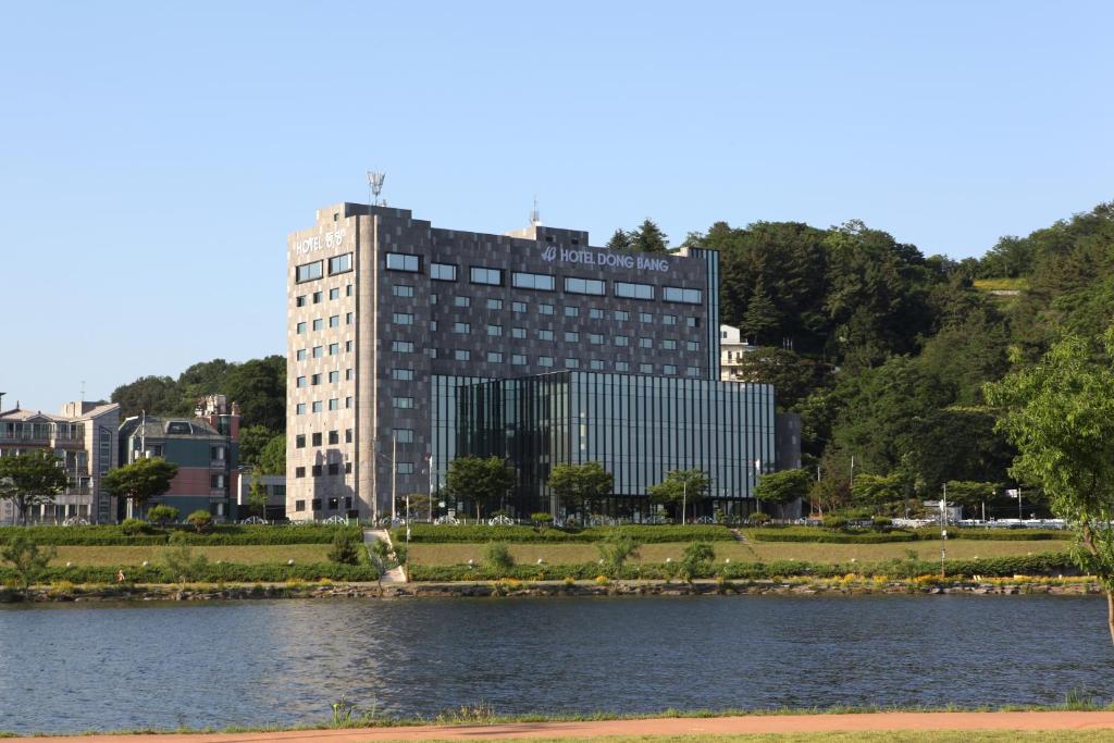 a tall building in front of a body of water at Hotel Dongbang in Jinju