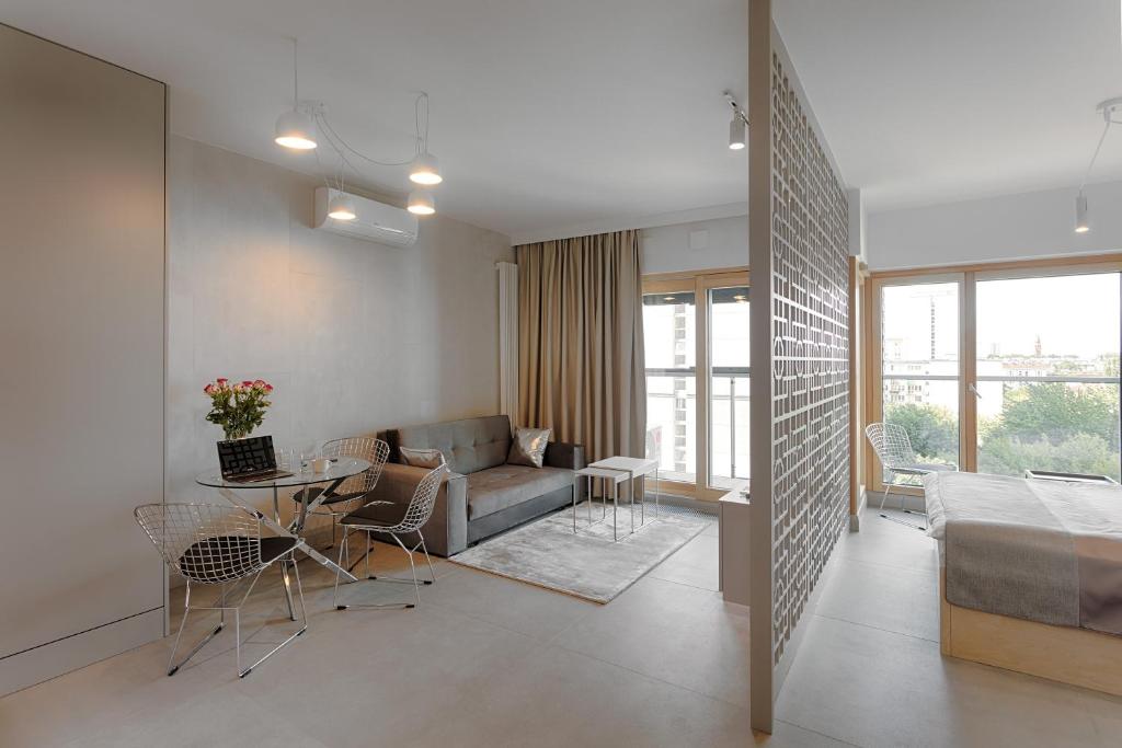 a living room with a couch and a table at Mennica Residence in Warsaw
