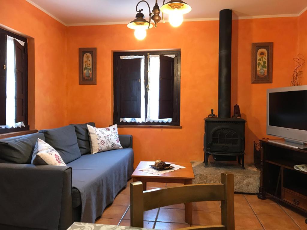 a living room with a blue couch and a stove at Les Piperes in Corao
