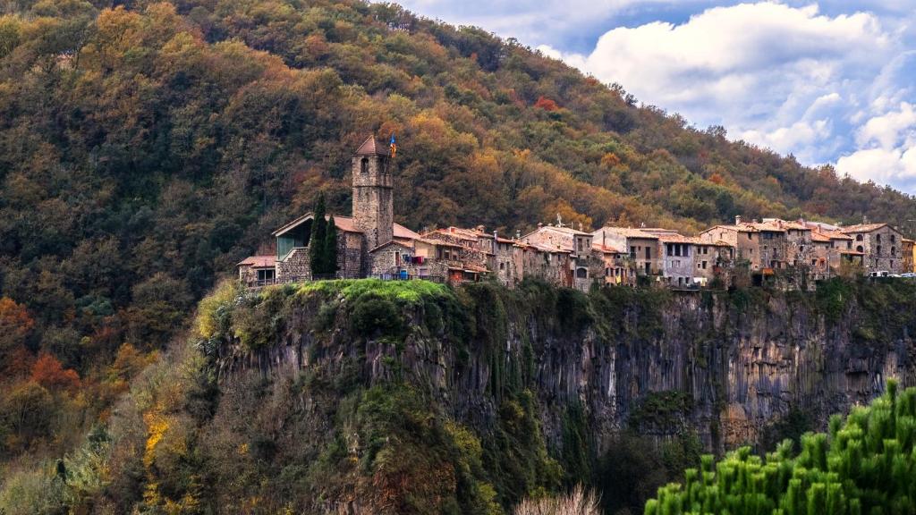 un villaggio su una montagna con un edificio sopra di Cala Clareta a Castellfollit de la Roca