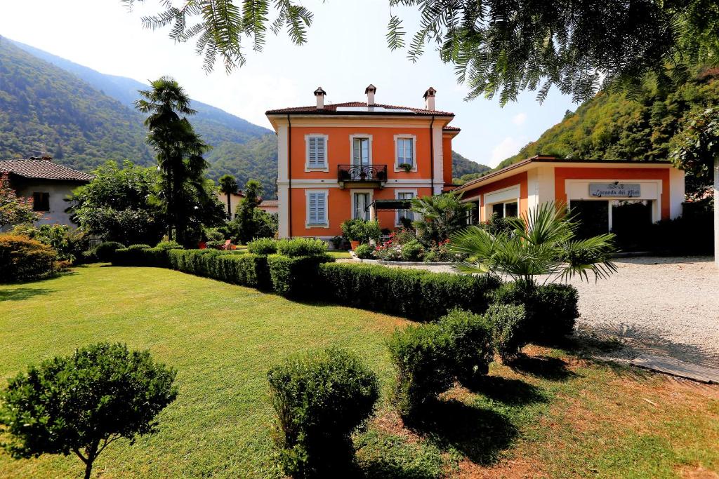 una casa arancione con una recinzione di fronte a un cortile di B&B Villa Dei Pini a Cannobio