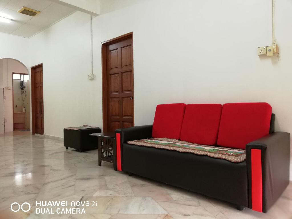 a black couch with red cushions in a room at Taiping Guest House in Taiping