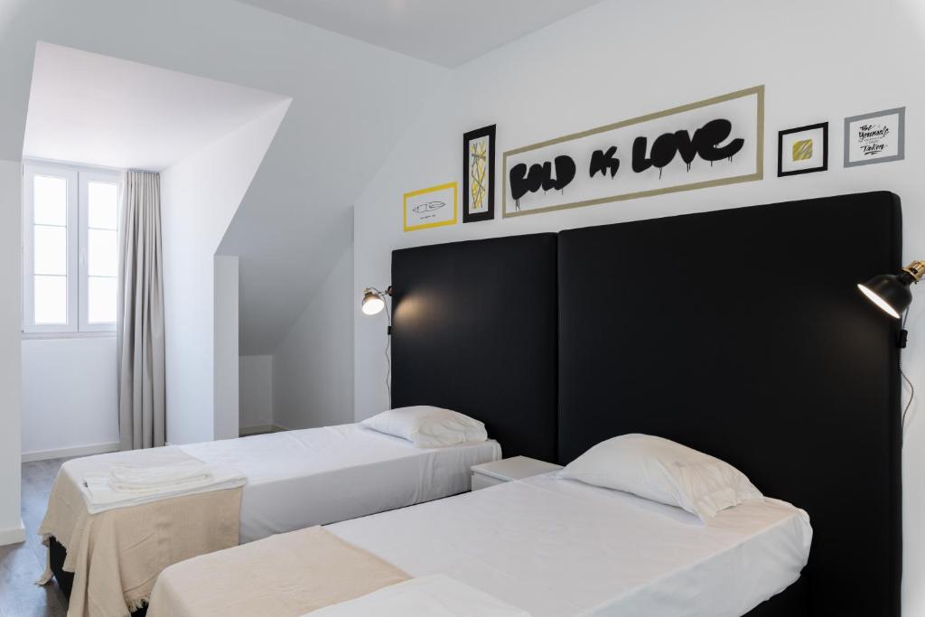 リスボンにあるCity Stays Atalaia Apartmentsの白い壁の客室内のベッド2台