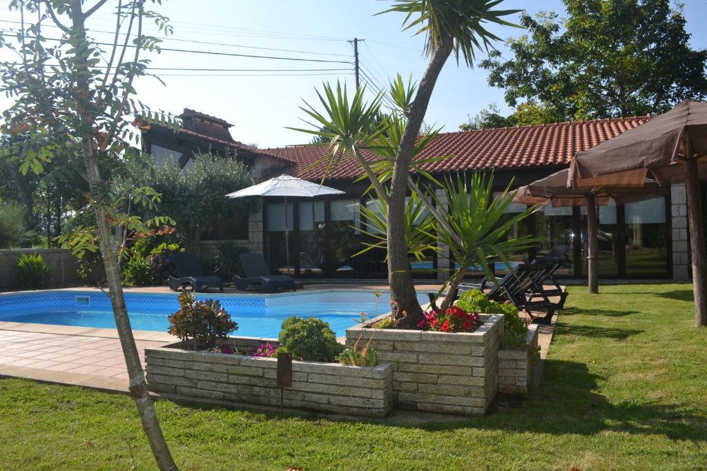 uma casa com piscina e palmeiras num quintal em Alagoas4Family - Country House em Arouca