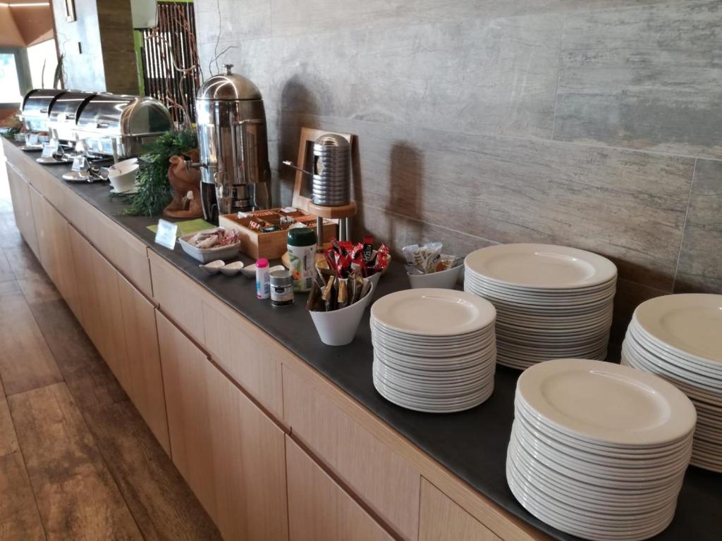 a buffet line with white plates on a counter at Hotel Vinotel Gospoja in Vrbnik