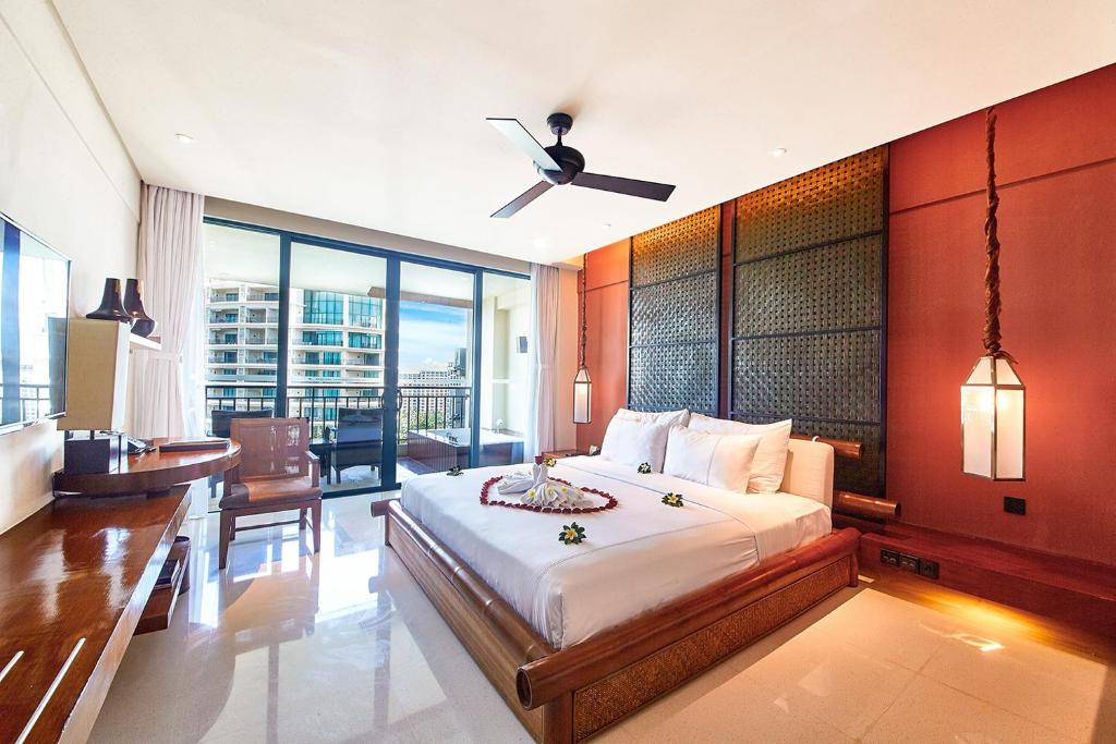a bedroom with a large bed with a ceiling fan at Ocean Sonic Resort Sanya in Sanya