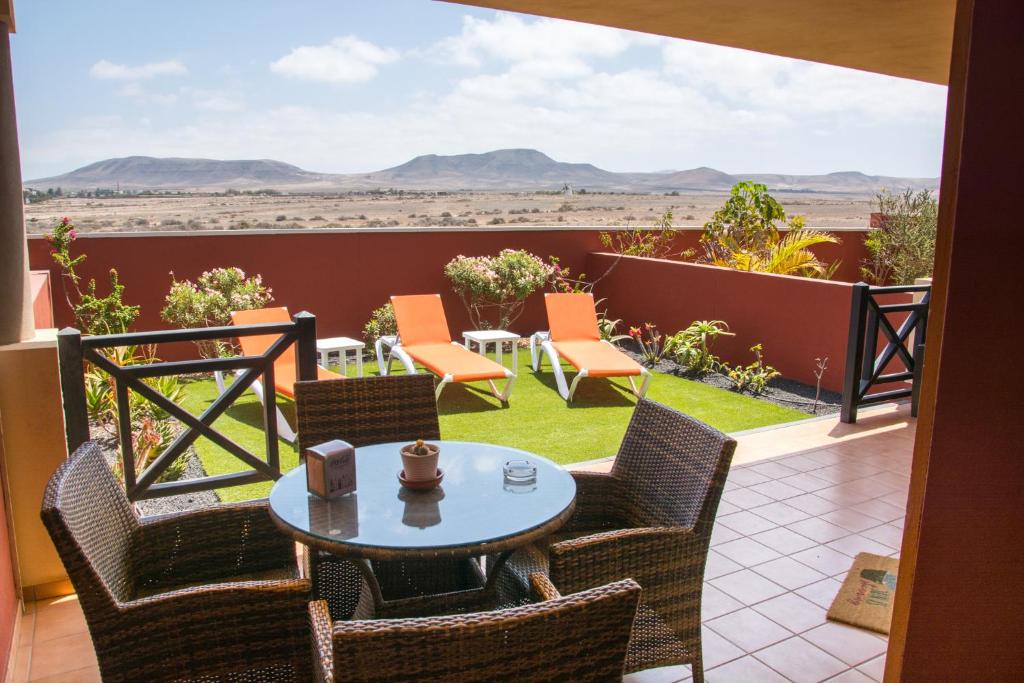 d'une terrasse avec une table et des chaises et une vue sur le désert. dans l'établissement Casa Nesea, à El Cotillo