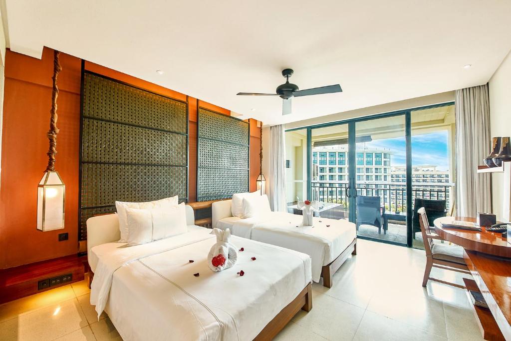 a hotel room with two beds and a balcony at Ocean Sonic Resort Sanya in Sanya