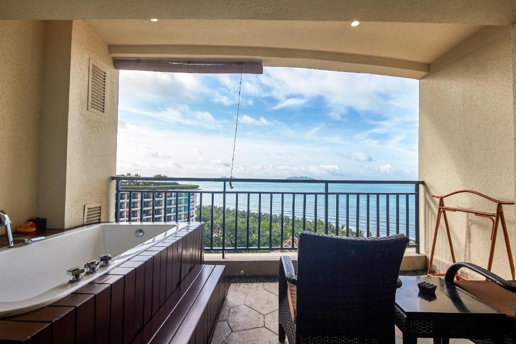 a bathroom with a tub and a view of the ocean at Ocean Sonic Resort Sanya in Sanya