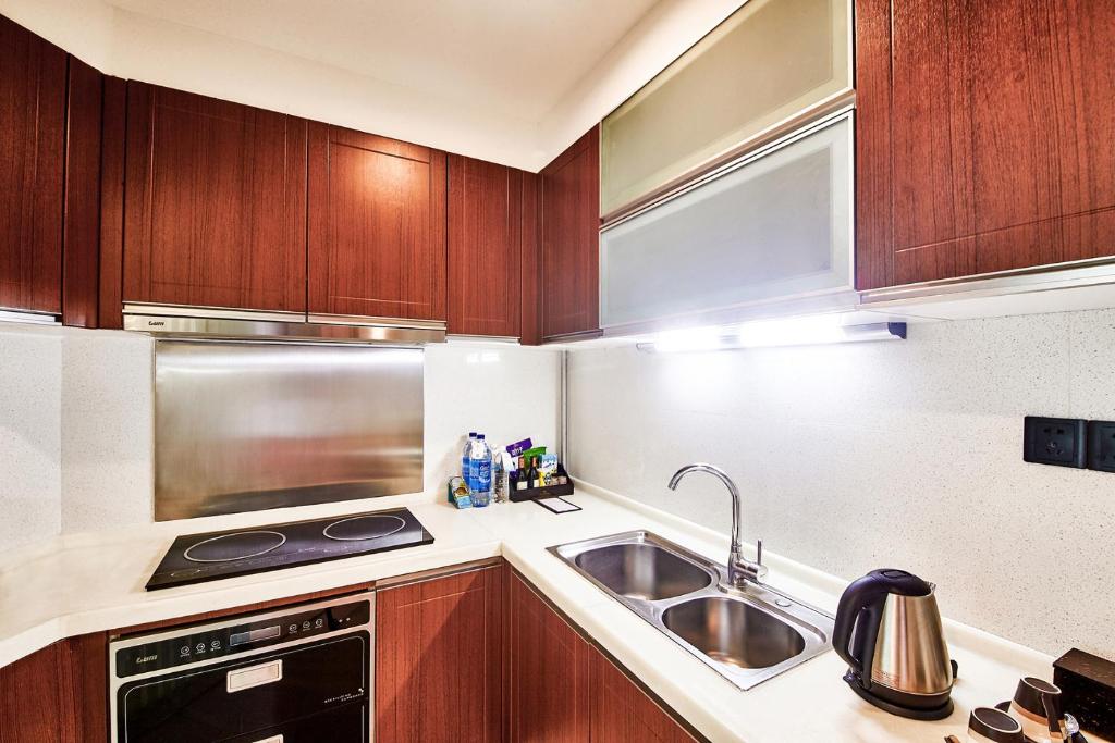 a kitchen with a sink and a stove top oven at Ocean Sonic Resort Sanya in Sanya