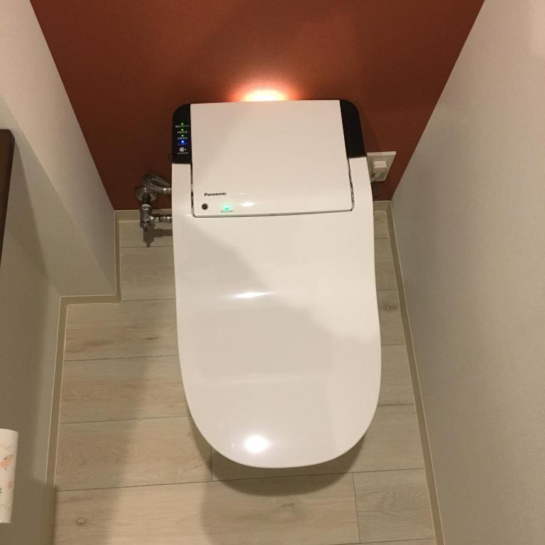 a white toilet with a light on top of it at Tokyo inn Sakura An in Tokyo