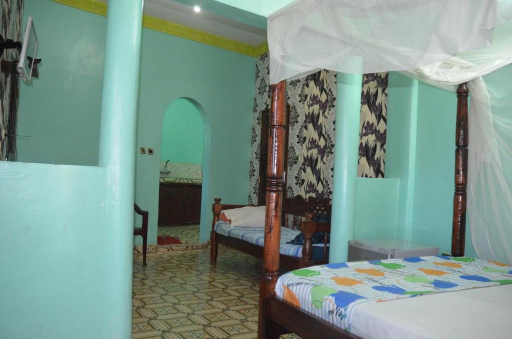 a bedroom with two beds with blue walls at Young Safari Hotel in Malindi