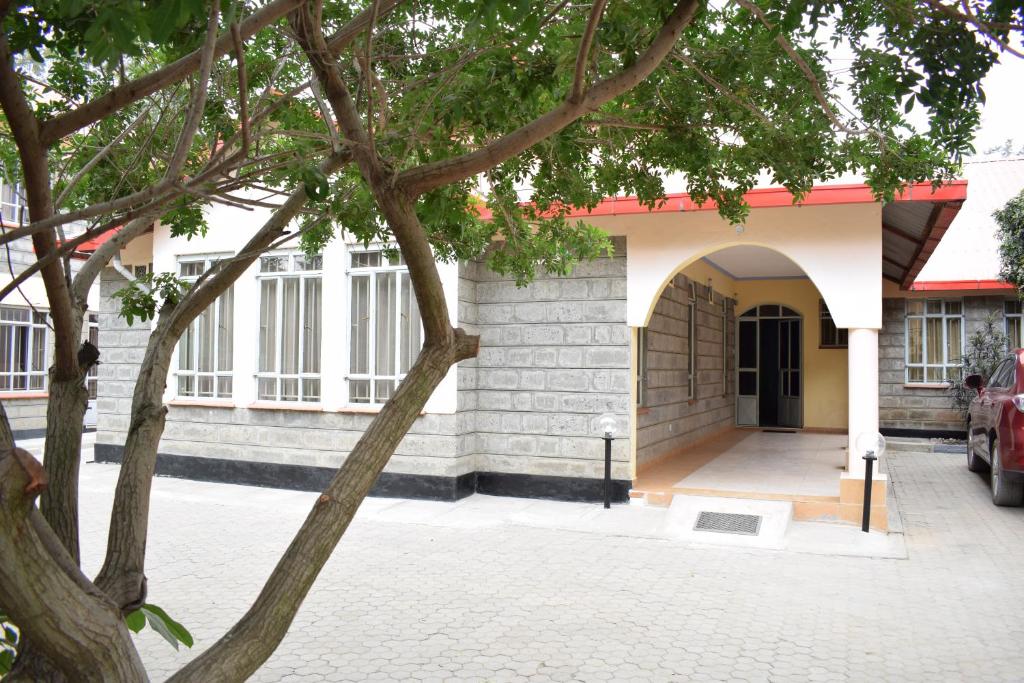 ein Gebäude mit einem Torbogen und einer Einfahrt in der Unterkunft Tommy's Airport Lounge in Nairobi