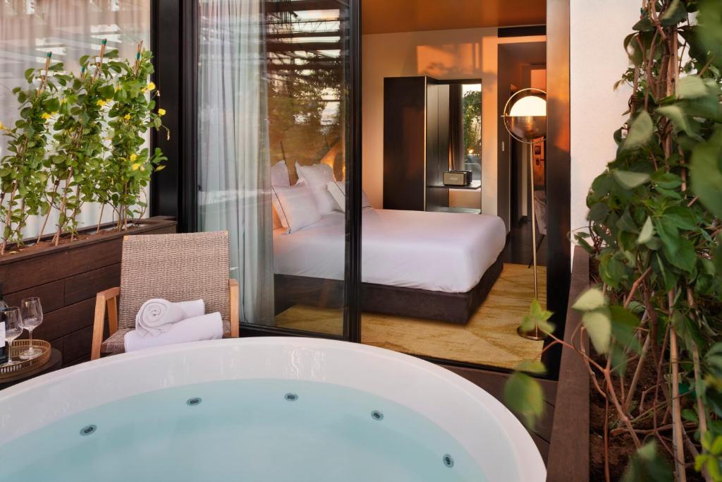 a bath tub in a room with a bedroom at Brown Lighthouse Tel Aviv, a member of Brown Hotels in Tel Aviv