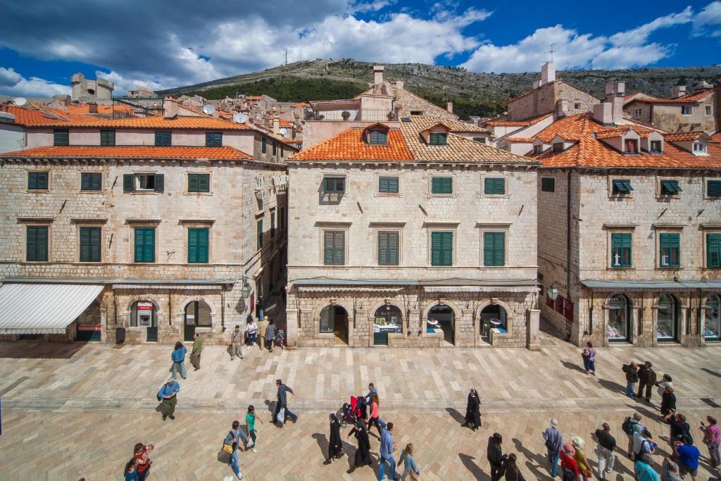 un grupo de personas caminando por una ciudad en Apartments & Rooms Orlando, en Dubrovnik