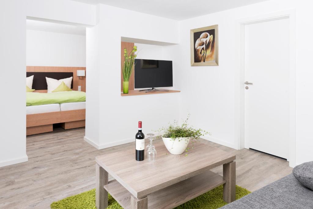 a living room with a table and a bed at Hotel Garni BURG WALDENSTEIN in Rudersberg