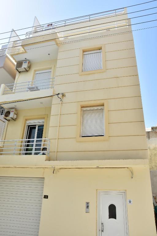 a yellow house with a white garage at Chalkidonos in Heraklio